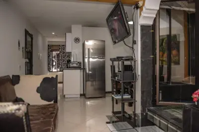 a living room with a refrigerator and a tv at Calle 8 101 in Medellín