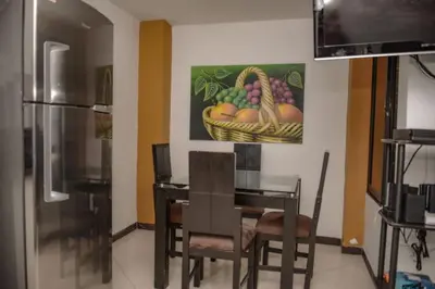 a dining room with a table and a painting of fruit at Calle 8 101 in Medellín