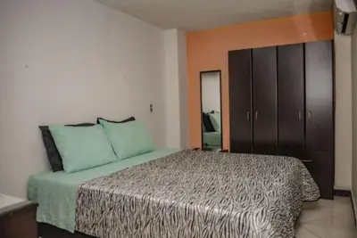 a bedroom with a large bed with blue pillows at Calle 8 101 in Medellín