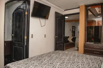 a bedroom with a bed and a flat screen tv at Calle 8 101 in Medellín