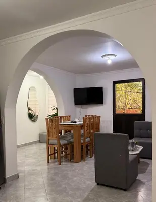 a dining room and living room with a table and chairs at Hermoso y amplio apartamento cerca al centro de Medellin in Medellín
