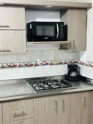 a kitchen with a microwave and a stove top oven at Hermoso y amplio apartamento cerca al centro de Medellin in Medellín