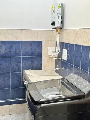 a toilet in a bathroom with blue tiles at Hermoso y amplio apartamento cerca al centro de Medellin in Medellín
