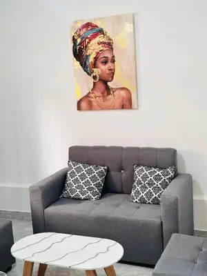 a living room with a couch and a painting on the wall at Hermoso y amplio apartamento cerca al centro de Medellin in Medellín