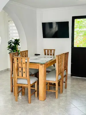 a dining room table with chairs and a television at Hermoso y amplio apartamento cerca al centro de Medellin in Medellín