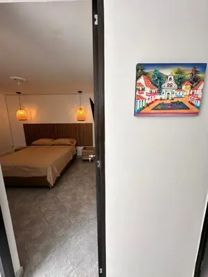 a room with a bed and a painting on the wall at Hermoso y amplio apartamento cerca al centro de Medellin in Medellín