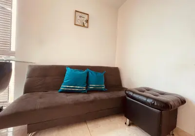a brown couch with two blue pillows on it at Mejor alojamiento cerca Provenza 191 in Medellín