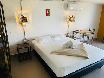 a bed in a bedroom with two tables and two lamps at Casa Hotel Cautiva in Sopetran