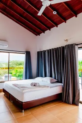 a bedroom with a large bed with blue curtains at Casa Hotel Cautiva in Sopetran