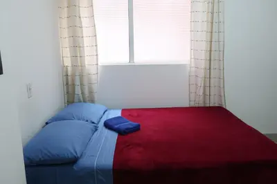 a bed in a room with a large window at Living Poblado Manila 3020 Habitación Doble in Medellín