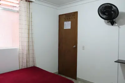 a room with a door and a fan on the wall at Living Poblado Manila 3020 Habitación Doble in Medellín