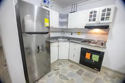 a kitchen with a stainless steel refrigerator and white cabinets at Living Poblado Manila 3020 Habitación Doble in Medellín