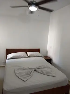a bedroom with a bed with a bow tie on it at occidente Santa Fe de Antioquia sol y playa in Santa Fe de Antioquia