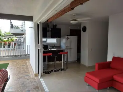 a living room with a red couch and a kitchen at occidente Santa Fe de Antioquia sol y playa in Santa Fe de Antioquia