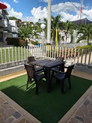 a black table and chairs on top of green grass at occidente Santa Fe de Antioquia sol y playa in Santa Fe de Antioquia