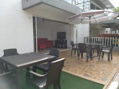 a patio with tables and chairs and an umbrella at occidente Santa Fe de Antioquia sol y playa in Santa Fe de Antioquia