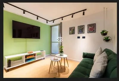 a living room with a green couch and a flat screen tv at Apartamento amoblado en Medellin! Solo Alquiler mensual!!! in Medellín