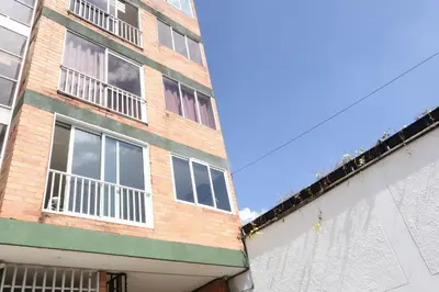 a brick building with white windows on the side of it at Living Poblado Manila 3029 Habitación Doble con Baño Privado in Medellín