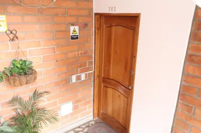 a wooden door next to a brick wall at Living Poblado Manila 3026 Habitación Individual in Medellín