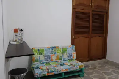 a couch with a quilt sitting in front of a door at Living Poblado Manila 3027 Habitación Individual in Medellín