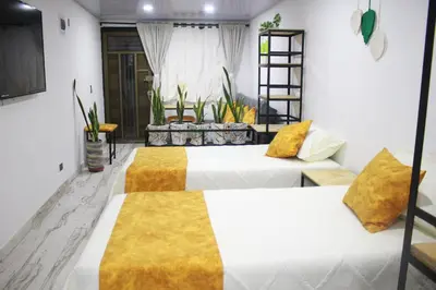 a bedroom with two beds and a couch at Cómodo loft en Medellín in Medellín