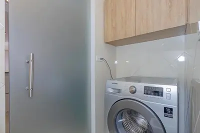 a washer and dryer in a kitchen with a cabinet at Alcazar de oviedo by Host Medellin in Medellín