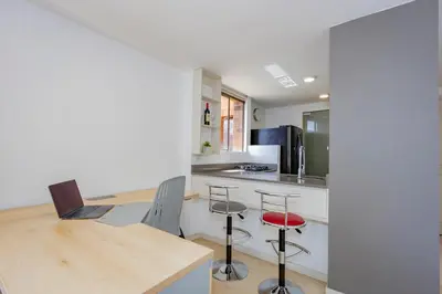a kitchen with a table with a laptop on it at Alcazar de oviedo by Host Medellin in Medellín