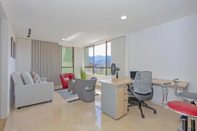 an office with a desk and chairs and a table at Alcazar de oviedo by Host Medellin in Medellín