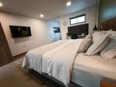 a bedroom with a large white bed and a television at Florentina Living 301 V in Medellín