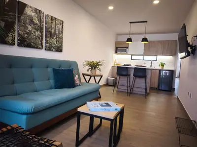a living room with a blue couch and a kitchen at Florentina Living 301 V in Medellín