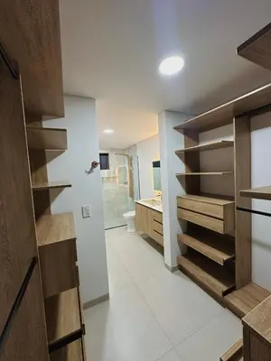 a bathroom with a walk in closet with wooden shelves at Casa Fénix in Marinilla