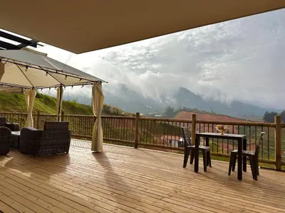 a deck with a table and chairs and a view of a mountain at Casa Fénix in Marinilla
