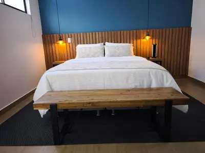 a bedroom with a large bed with a wooden wall at Florentina Living 302 A in Medellín