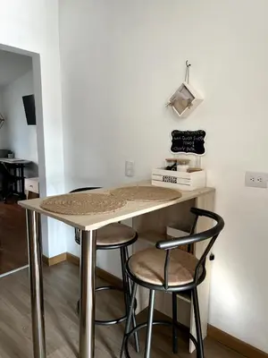 a table and two stools in a room at Lindos Apartamentos con Terraza in Manizales