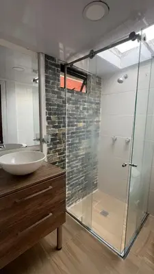 a bathroom with a glass shower and a sink at Lindos Apartamentos con Terraza in Manizales