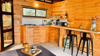 a kitchen with wooden walls and a counter with stools at Casa Tikkun in Medellín