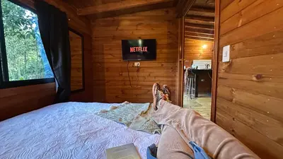 a person with their feet up on a bed in a cabin at Casa Tikkun in Medellín