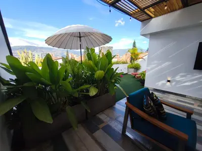 a balcony with an umbrella and plants and a bench at Florentina Living 401 in Medellín