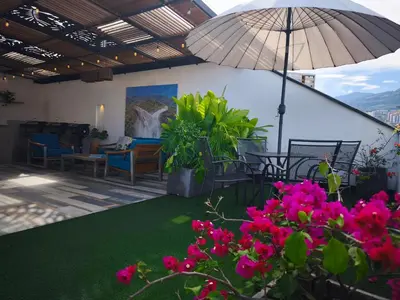 a patio with pink flowers and an umbrella at Florentina Living 401 in Medellín