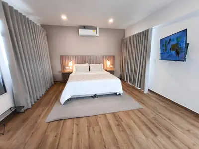 a bedroom with a white bed and wooden floors at Florentina Living 401 in Medellín