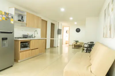 a kitchen and living room with a couch and a refrigerator at Apartamentos Montecarlo in Medellín