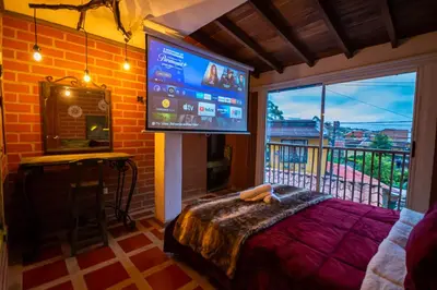 a bedroom with a large screen tv and a bed at Hotel Spa Bliss Guatape in Guatapé