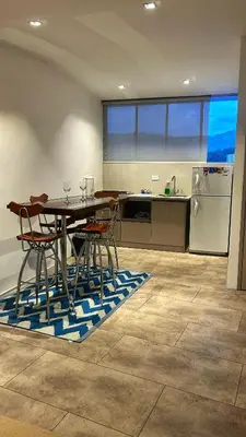 a kitchen with a table and chairs and a refrigerator at Cómodo, amplio y relajante Apto, cerca a Cable plaza y sector Milán in Manizales
