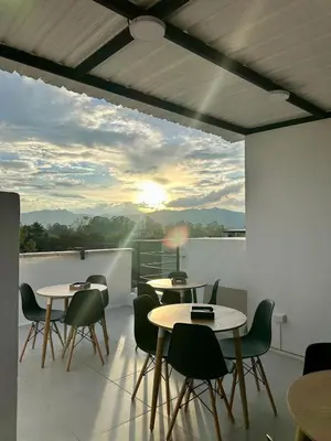 a room with tables and chairs on a balcony at Hotel Med Llanogrande in Rionegro