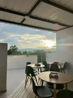 a patio with tables and chairs on a roof at Hotel Med Llanogrande in Rionegro