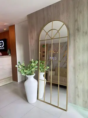 a room with a mirror and a vase with a plant at Hotel Med Llanogrande in Rionegro