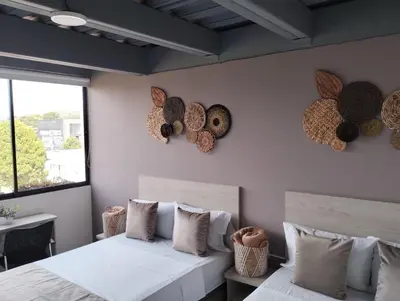 a bedroom with two beds and two windows at Hotel Med Llanogrande in Rionegro
