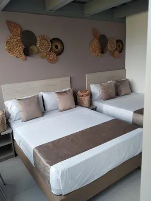 two beds sitting next to each other in a room at Hotel Med Llanogrande in Rionegro