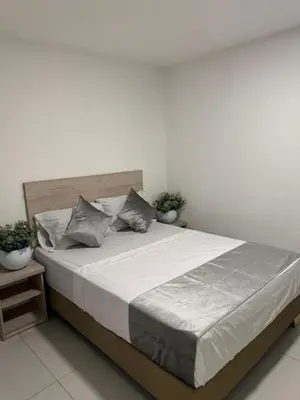 a bed in a bedroom with two potted plants at Hotel Med Llanogrande in Rionegro
