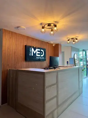a reception desk with a laptop on top of it at Hotel Med Llanogrande in Rionegro